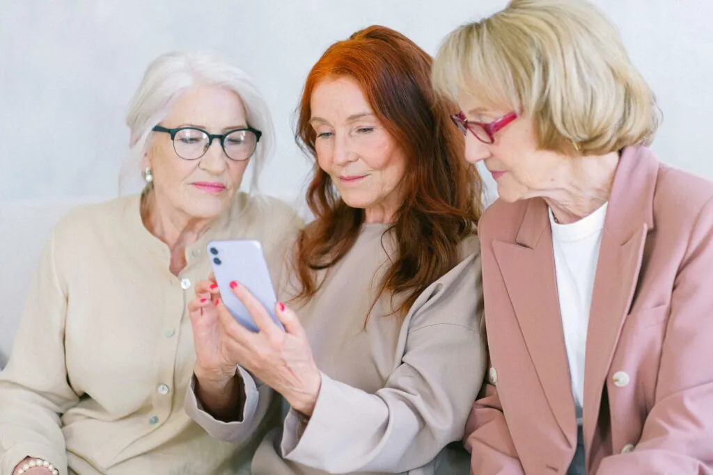 a group of women looking at a phone
