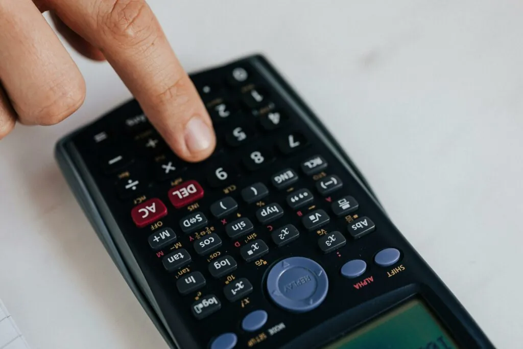 a finger pressing a calculator