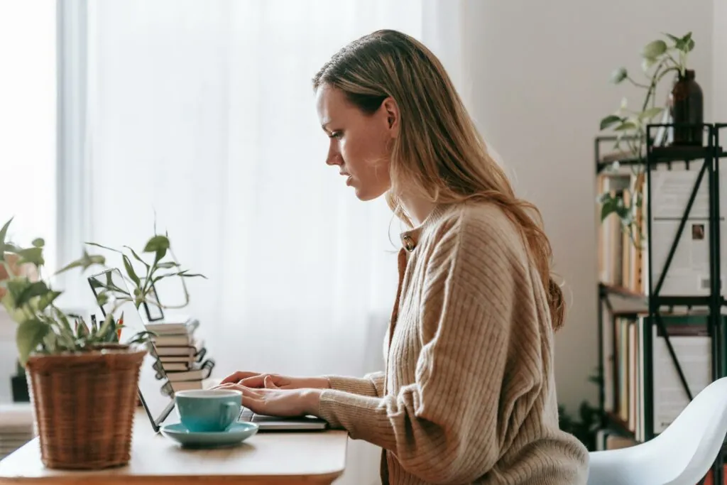 a woman sitting at a desk using a laptop