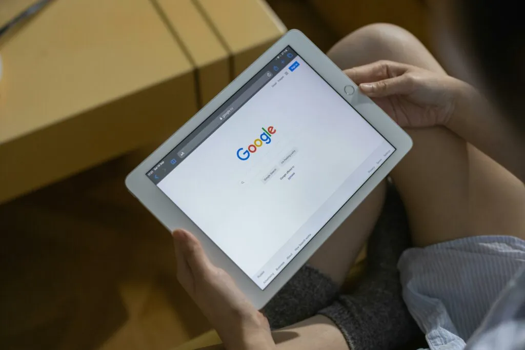 a person holding a tablet and référencement on Google