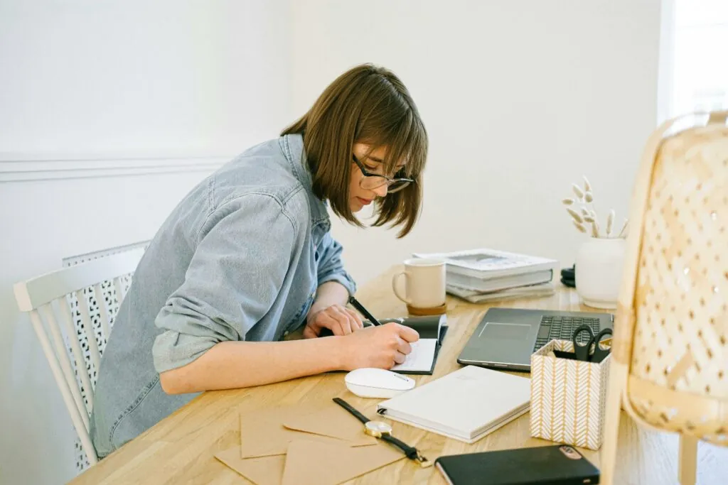 a woman writing on a notebook