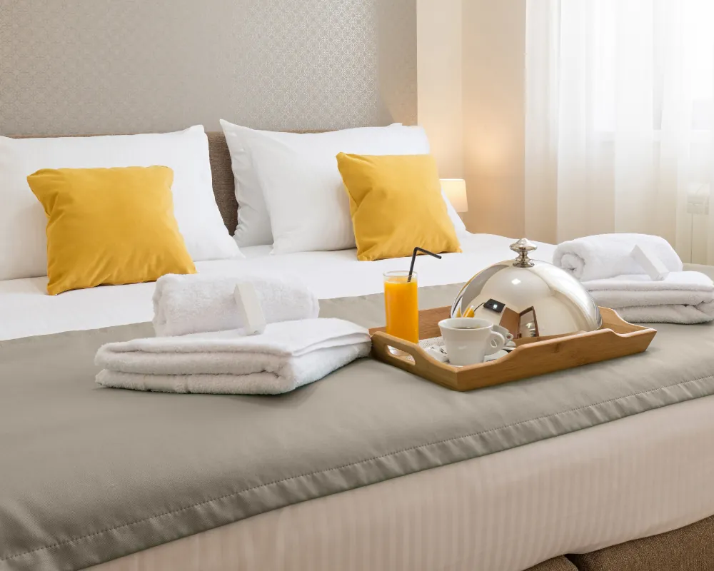 a tray of towels and a tray of tea on a bed